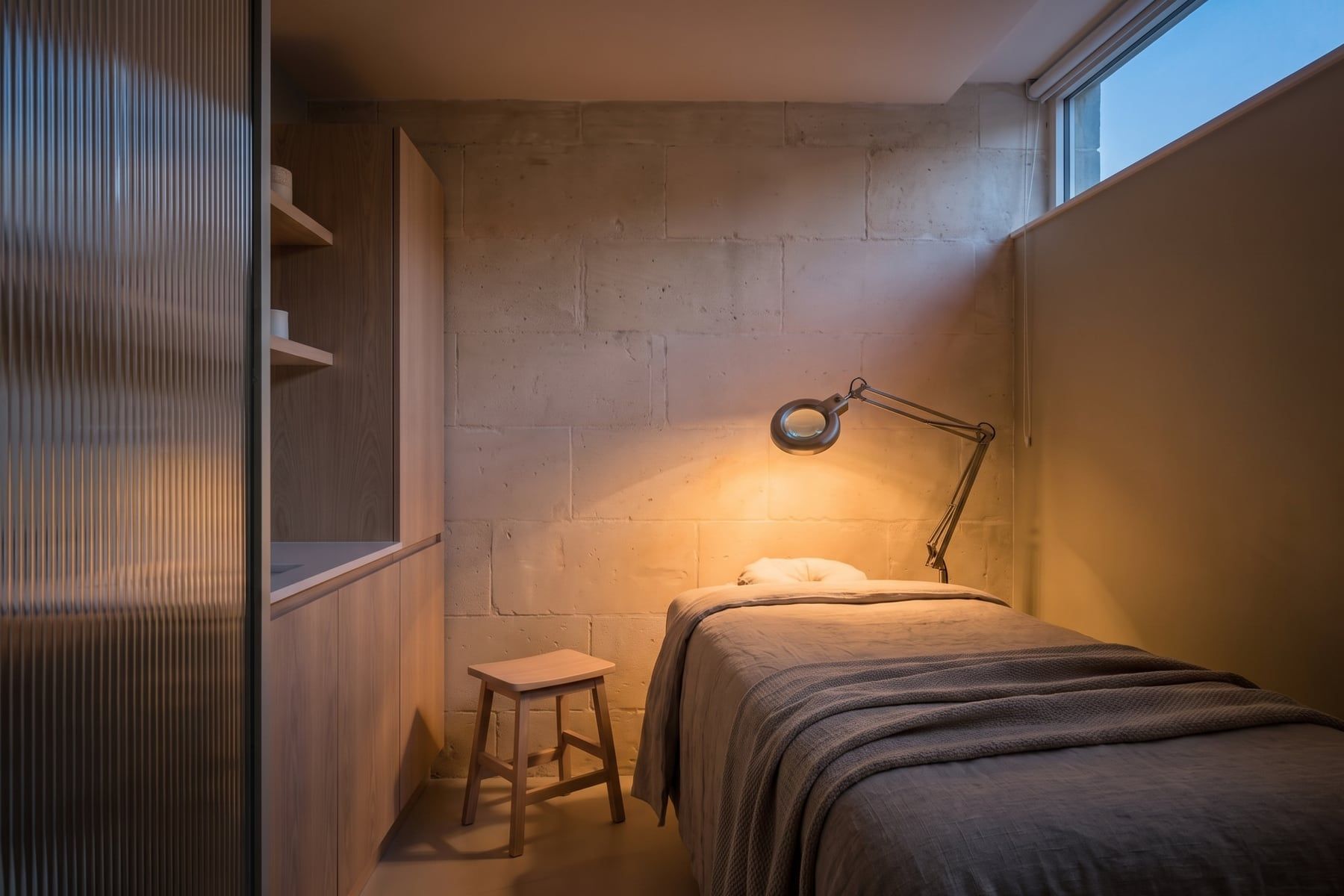 Evening: the same treatment room in cool morning daylight and warm evening lamplight
